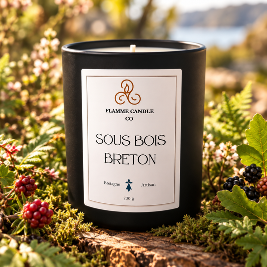 Bougie Sous Bois Breton posée sur de la mousse parmi des baies rouges et des fougères