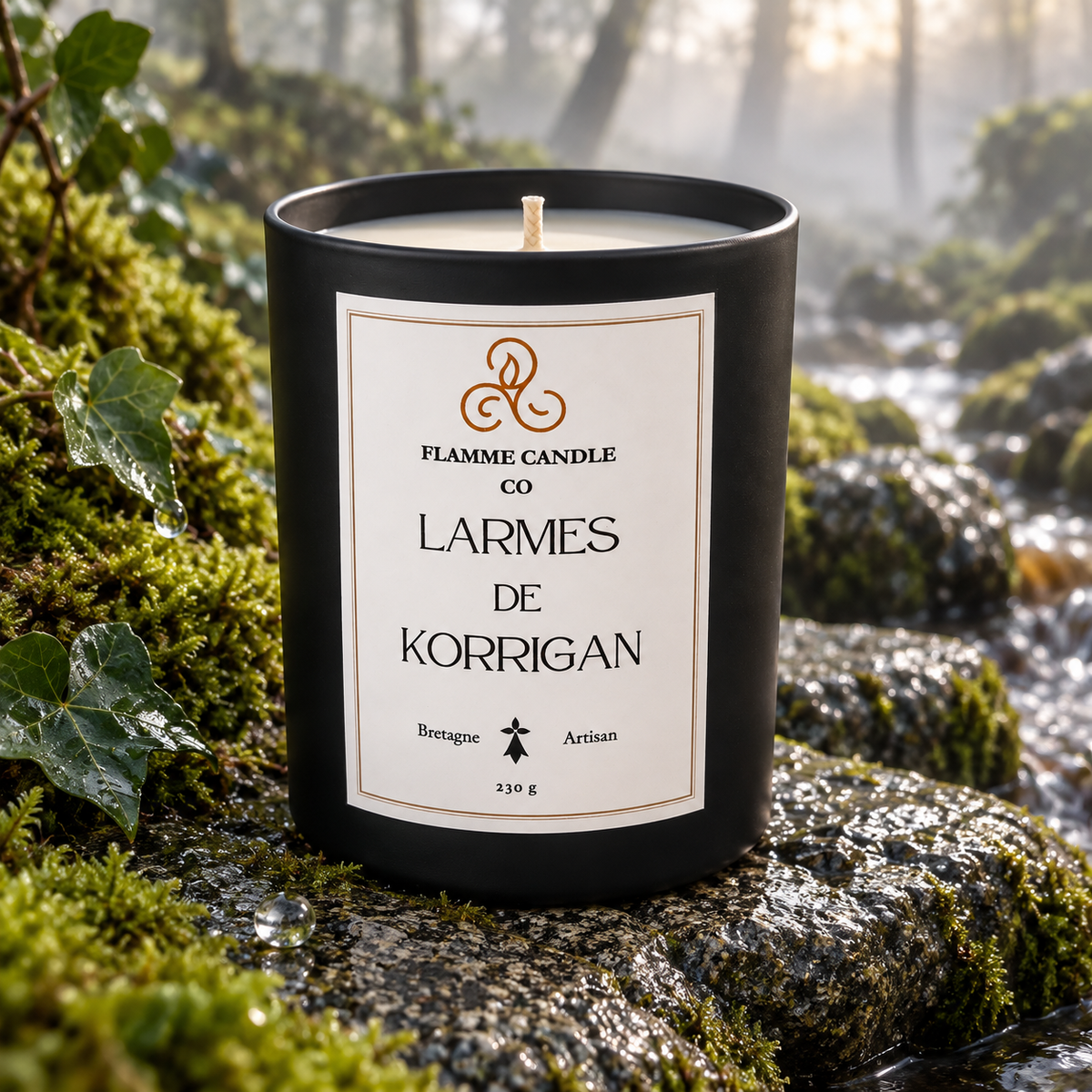 Bougie Larmes de Korrigan sur une pierre couverte de mousse, avec un ruisseau et la forêt en arrière-plan