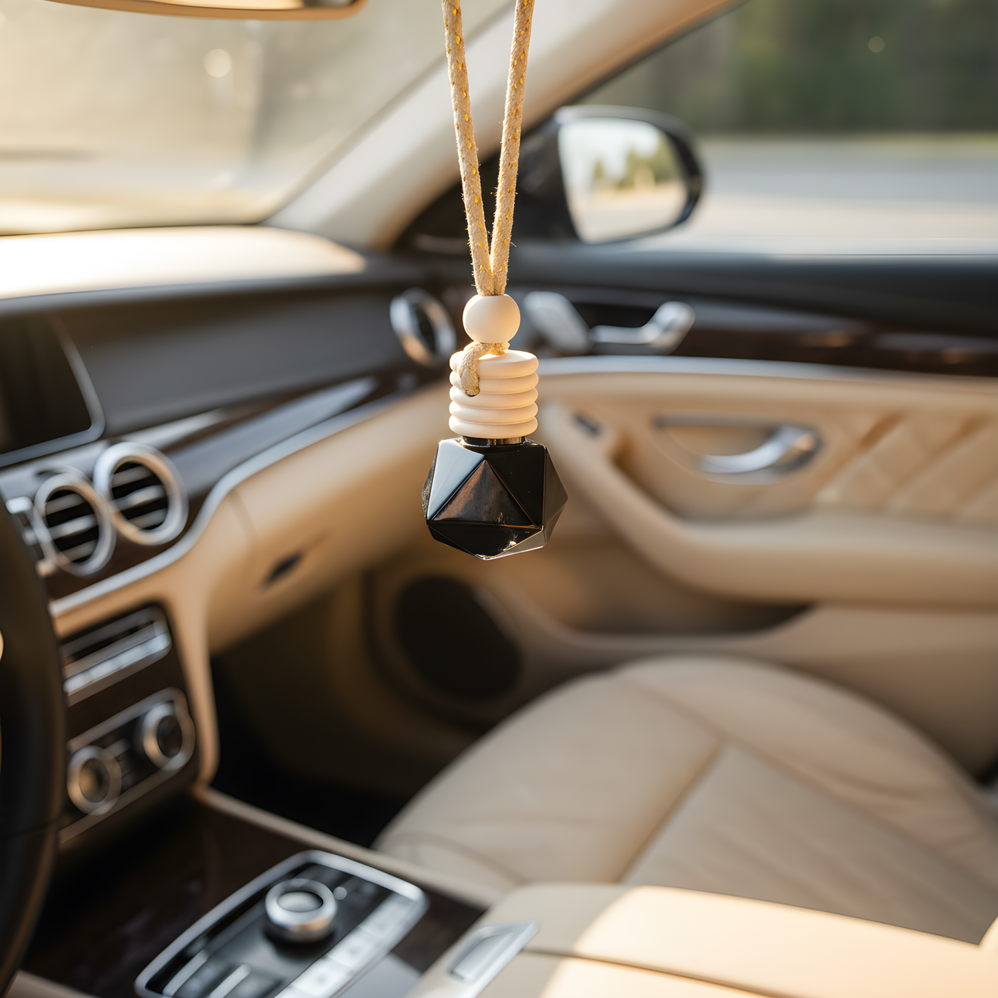 Elegant refillable car air freshener hanging in a luxury car interior, adding style and fragrance.
